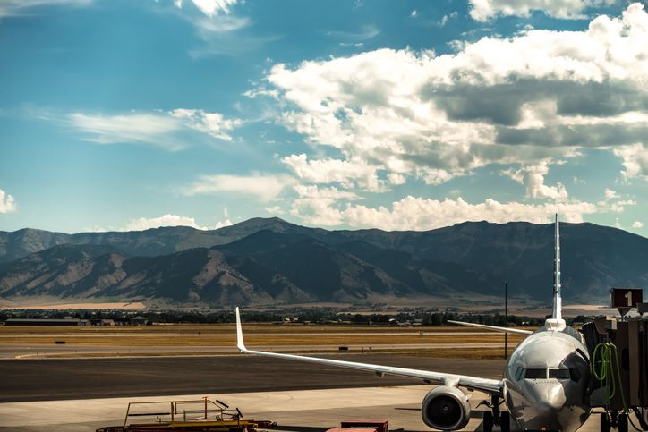 Commercial aircraft at a Montana airport with mountain range in background