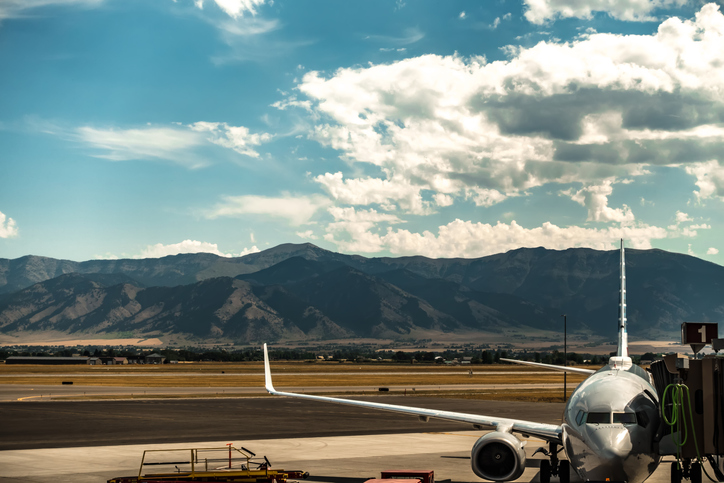 Commercial aircraft at a Montana airport with mountain range in background